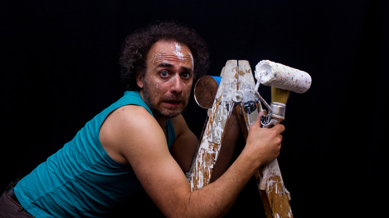 Người đàn ông sợ hãi trên một cái thang