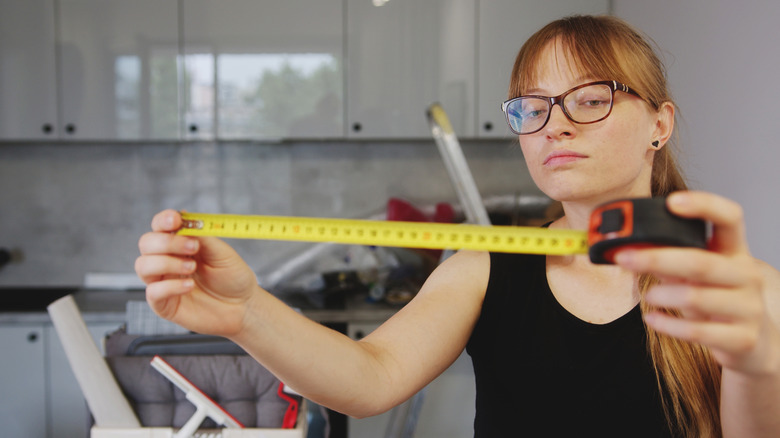 Người phụ nữ đo lường trước khi bắt đầu một dự án