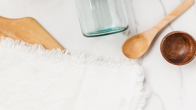 Mason Mason trống trên quầy bếp bằng đá và bình có cây xanh