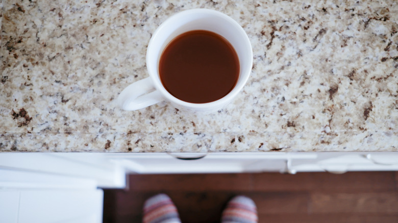 Tách cà phê ngồi trên mặt bàn đá granite màu nâu