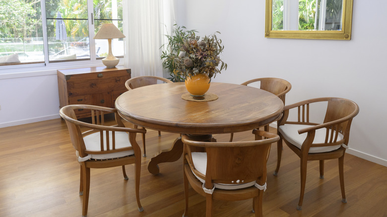 Phòng ăn với bàn tròn gỗ có tông màu trung bình phù hợp và ghế sau cong