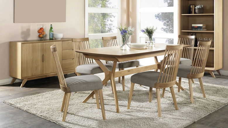 Phòng ăn đầy đồ nội thất bằng gỗ nhẹ phù hợp: bàn, sáu ghế, tủ sách và bảng phụ