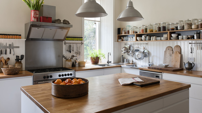 Nhà bếp với tông màu trắng và gỗ, cảm giác mộc mạc hơn với kệ mở và áo bán đồ tể