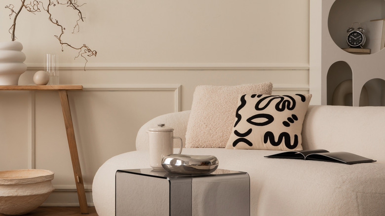 Phòng khách với những bức tường màu be, ghế sofa màu be, và màu be, gỗ và màu đen