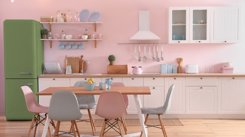 nhà bếp với tường màu hồng và trang trí màu hồng, xanh lá cây và xanh