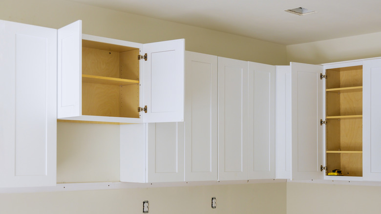 tủ màu trắng, một số có cửa mở, hiển thị không gian ở trên cùng với trần nhà