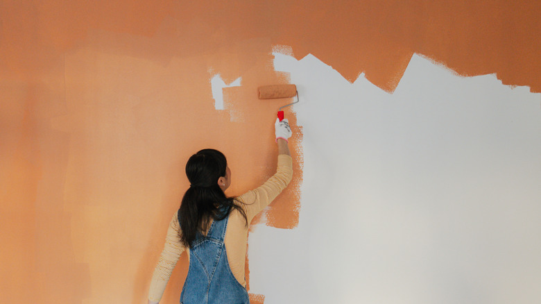 bức tường vẽ người phụ nữ với sơn màu cam mặc áo màu cam và áo khoác màu xanh lam