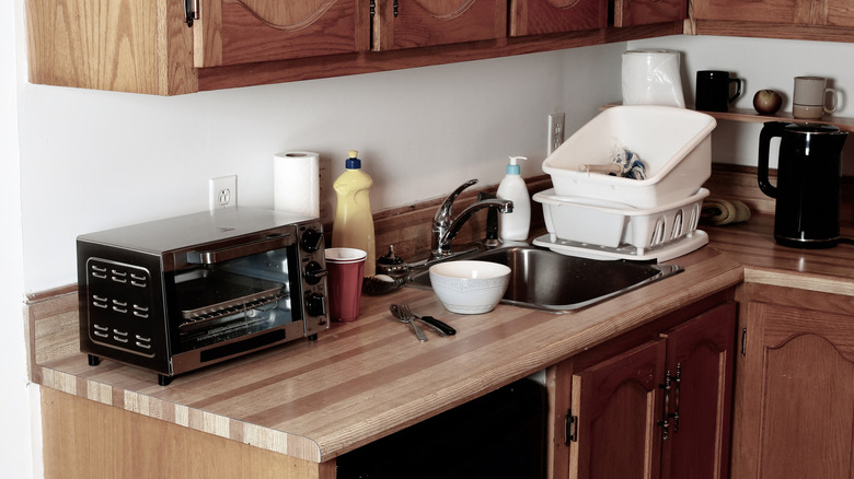 Quầy nhà bếp bằng gỗ với dụng cụ và lộn xộn