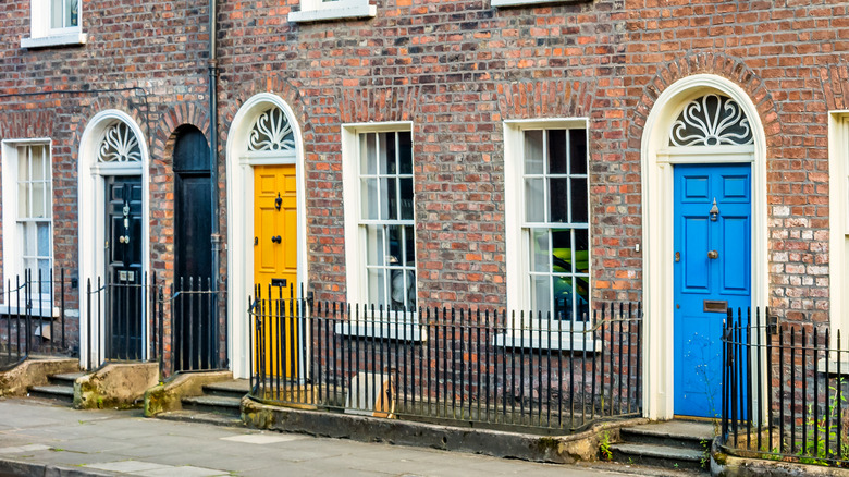 Nhà phố gạch lịch sử với cửa trước màu khác nhau.