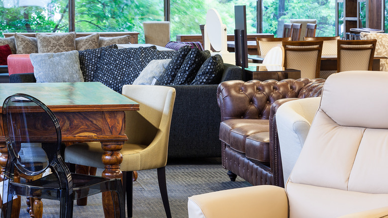 Phòng trưng bày đồ nội thất có rất nhiều mảnh khác nhau bao gồm ghế bành Lucite màu đen, ghế da chần và ghế sofa màu đen.