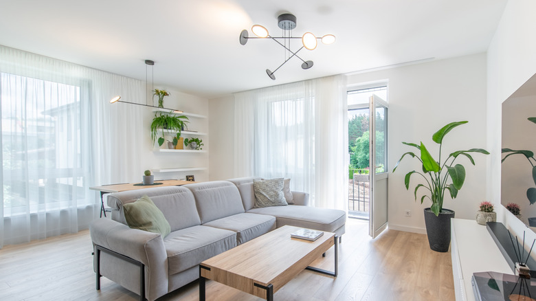 Phòng khách và phòng ăn với đèn chùm phù hợp và đồ đạc hiện đại gắn kết màu đen