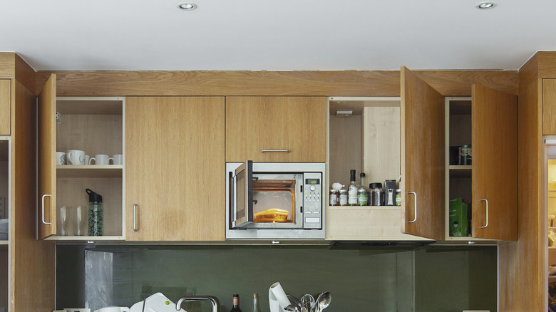 tủ gỗ trong nhà bếp vươn ra trần nhà và mở một số cửa