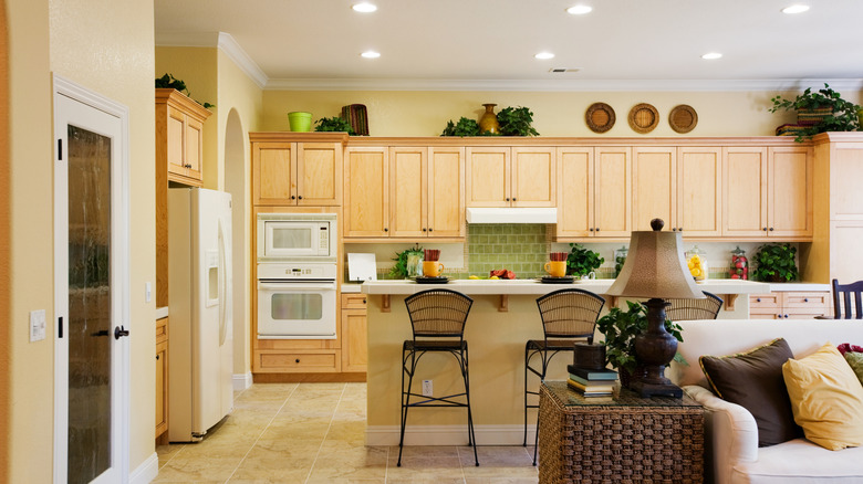 Một nhà bếp ấm áp với tủ chiều cao tiêu chuẩn hiển thị thực vật và giỏ dệt