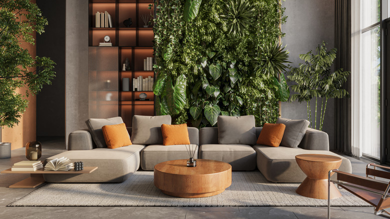 Phòng khách với một bức tường thực vật sống phía sau ghế sofa