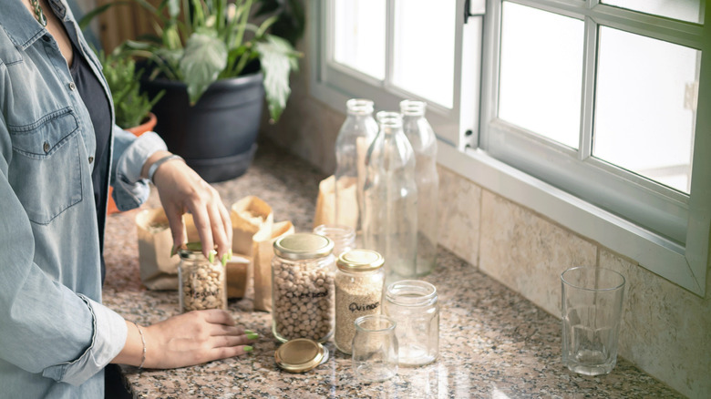 người phụ nữ tái sử dụng lọ thủy tinh để lưu trữ