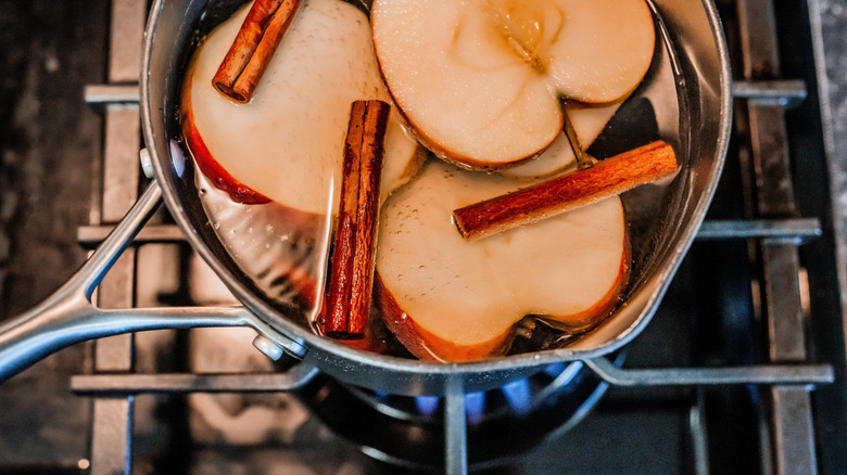 Nồi táo và que quế sôi trên bếp