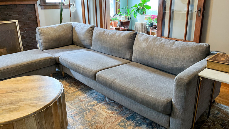 ghế sofa màu xám trong phòng khách với đệm chắc chắn