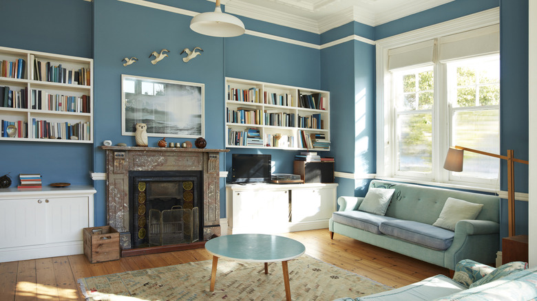 Lò sưởi màu xanh đậm trong phòng có hình nền hoa