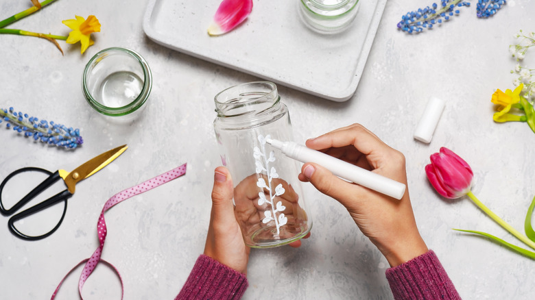 Người vẽ hoa trên lọ thủy tinh với điểm đánh dấu màu trắng