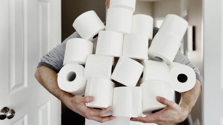 Người đàn ông cầm cuộn giấy vệ sinh