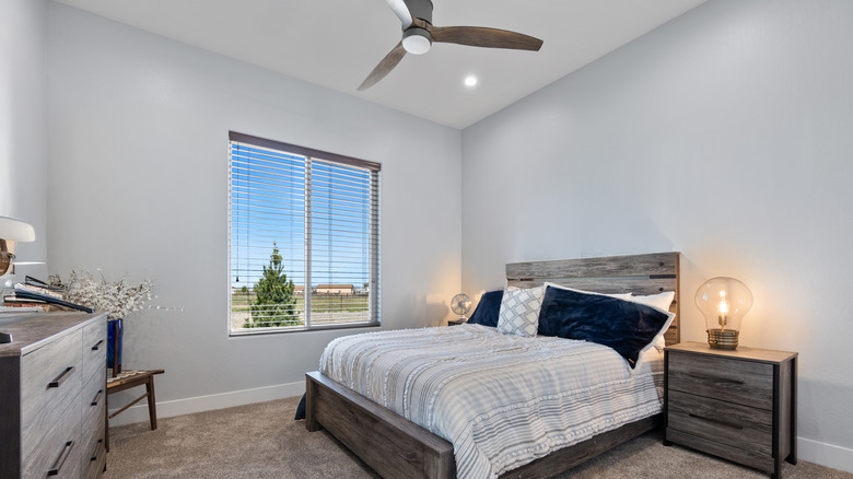 Phòng ngủ ấm cúng với giường thoải mái, tủ quần áo, đầu giường và quạt trần