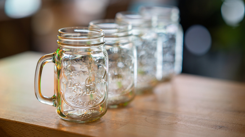 Mason trống rỗng xếp hàng trên bề mặt gỗ