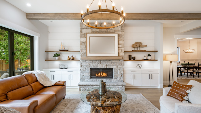 Phòng khách với lò sưởi bằng đá được bao quanh bởi giá đỡ tích hợp