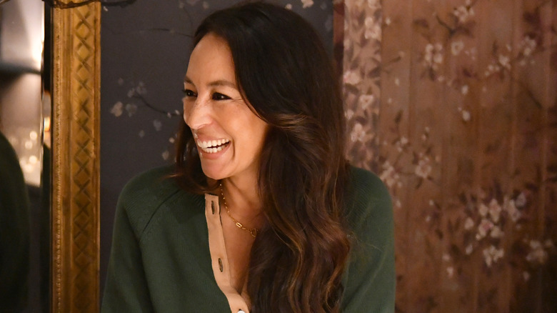 Joanna Gaines mỉm cười trong chiếc áo len màu xanh lá cây