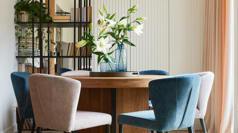 Phòng ăn hiện đại với những chiếc ghế bọc nhung, hoàn thiện tường kết cấu và màn treo mềm mại