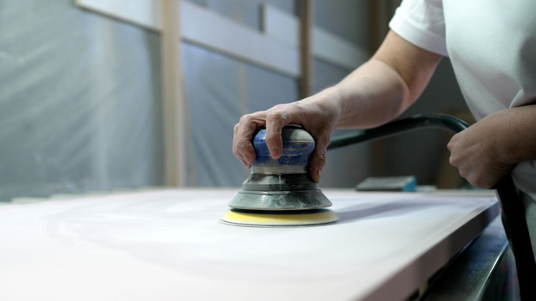 Chà nhám một tấm bảng bằng tay