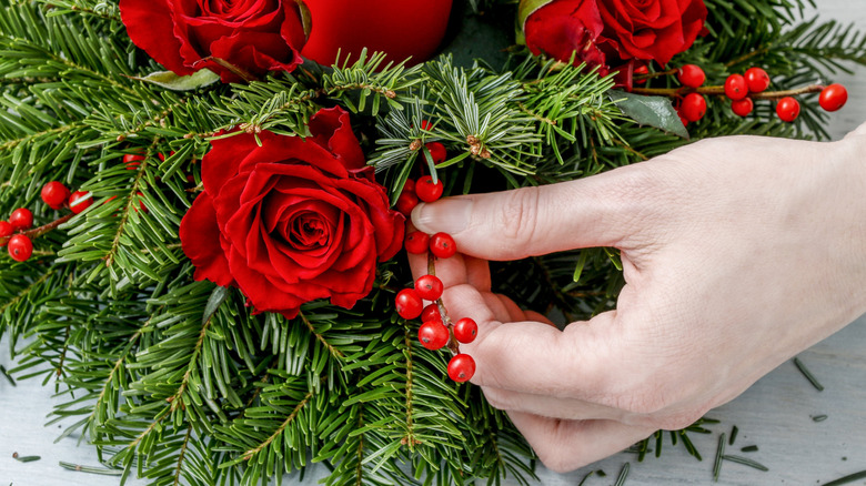 Làm vật trang trí trung tâm bằng cành thông và quả mọng đỏ