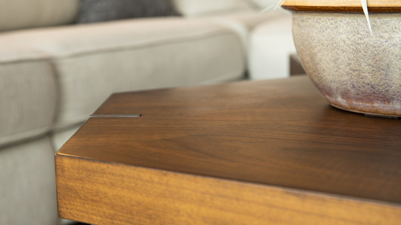 Bàn cà phê cũ trong phòng khách với chậu đá trên đó