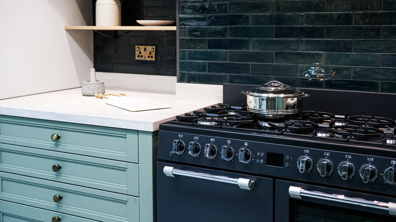 nhà bếp hiện đại với tấm ốp tường bếp màu xanh đậm