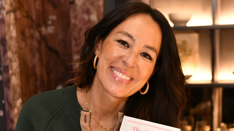 Joanna Gaines mỉm cười khi cầm một cuốn sách