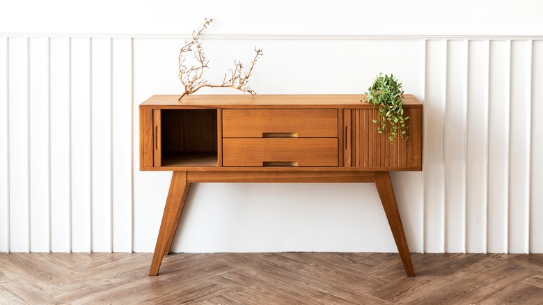 Một chiếc bàn hiện đại mang phong cách trung cổ với một cành cây và một cái cây ở trên