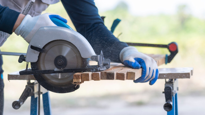 người cắt gỗ 2 x 2 bằng cưa tròn