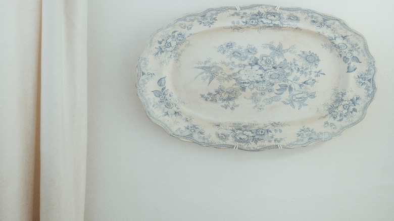 Chiếc đĩa cổ điển trên bức tường trắng cạnh tấm rèm