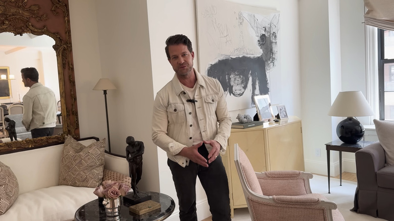 Nate Berkus đứng trước bức tường được trang trí