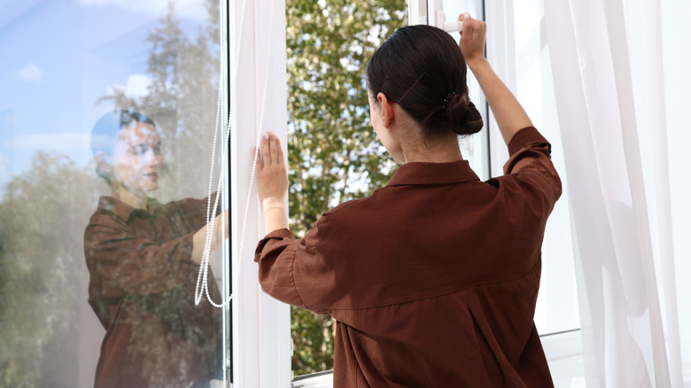 Người phụ nữ mở cửa sổ