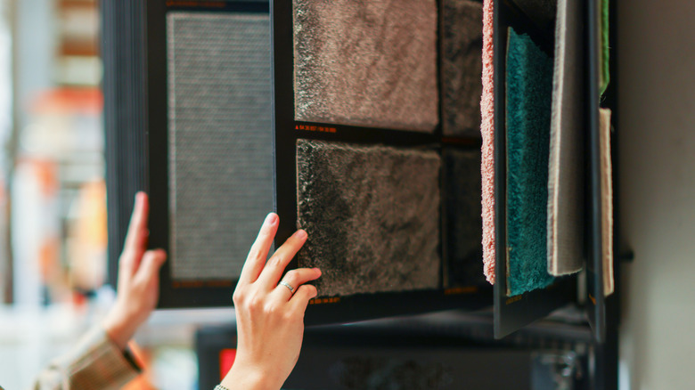 Người đang lướt qua các mẫu thảm tại cửa hàng.