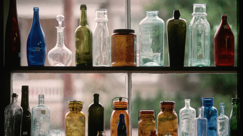 kính cổ điển với nhiều màu sắc khác nhau trên kệ trước cửa sổ