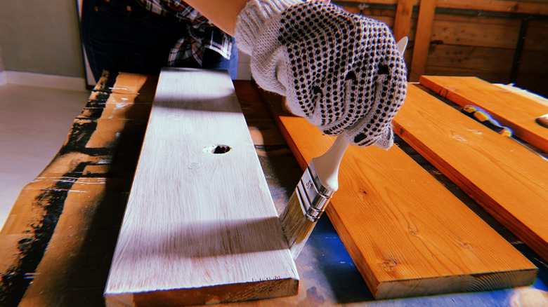 Một người phụ nữ đang vẽ tấm ván thủ công