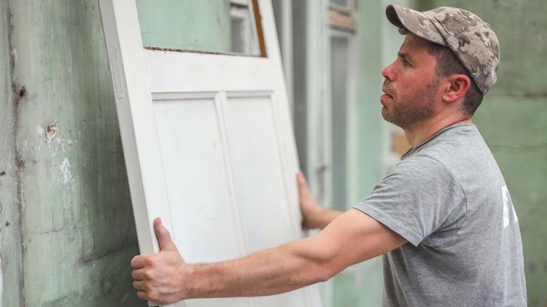 Người đàn ông lấy cánh cửa cũ để tái sử dụng