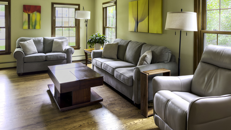 Phòng khách hiện đại với nội thất màu xám và tường xanh nhạt.