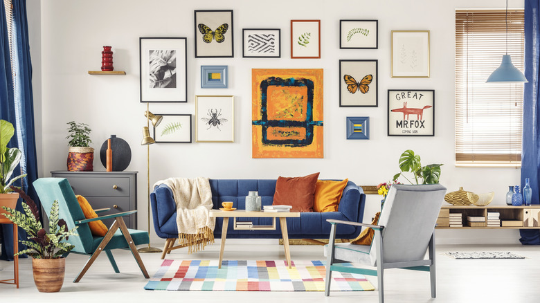 Một bức tường trưng bày với nhiều bức ảnh khác nhau được đóng khung và trưng bày