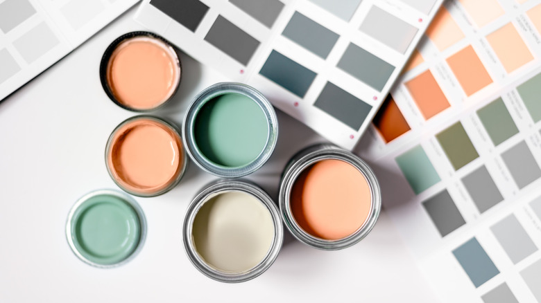 Mở thùng sơn bằng thẻ mẫu sơn trên bề mặt trắng.