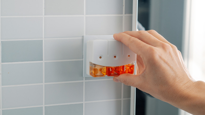 Tay cắm máy làm mát không khí vào ổ cắm trên tường