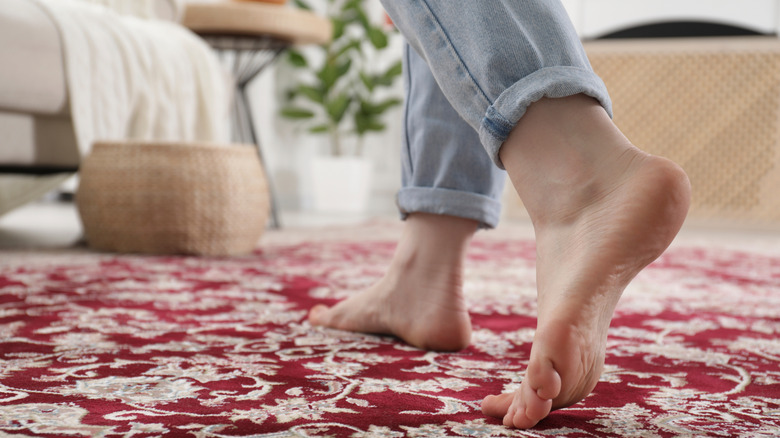 Người đi trên một tấm thảm in.