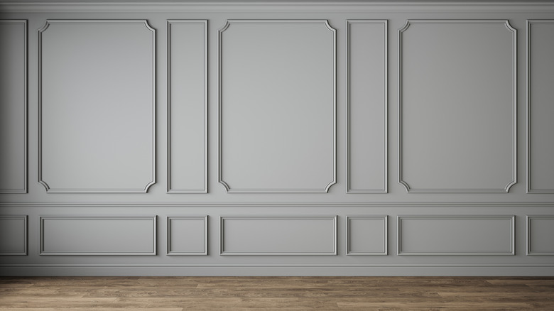 Bàn đặt chậu cây trước bức tường xanh có đường gờ trang trí