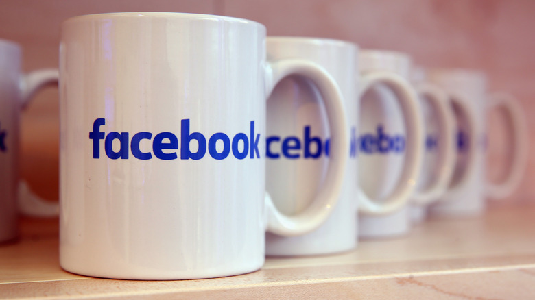 Một dãy cốc màu trắng có logo Facebook màu xanh trên đó